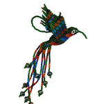 A handmade beaded hummingbird ornament featuring a vibrant mix of green, blue, red, and orange seed beads, with long trailing strands and iridescent bead accents, photographed on a plain white background.