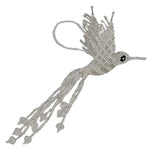 A handmade beaded hummingbird ornament, crafted with white and silver-toned seed beads, featuring a small black eye detail and a hanging loop at the top, set against a plain white background.