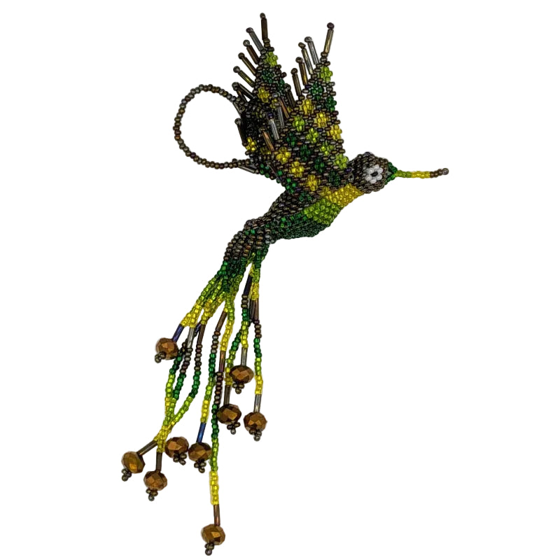 A handmade beaded hummingbird  ornament, featuring green, yellow, and iridescent dark brown seed beads with dangling bead strands and bronze color crystals, photographed against a plain white background.