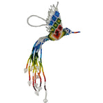 A handmade beaded hummingbird ornament with a vibrant multicolor design, featuring a silver wire loop at the top for hanging. The body and wings are crafted with blue, green, yellow, red, and orange beads, adorned with dangling clear crystal beads, set against a plain white background.