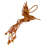 A handmade beaded hummingbird ornament crafted from orange,white, and red seed beads with a small white bead eye and a hanging loop, shown on a plain white background.