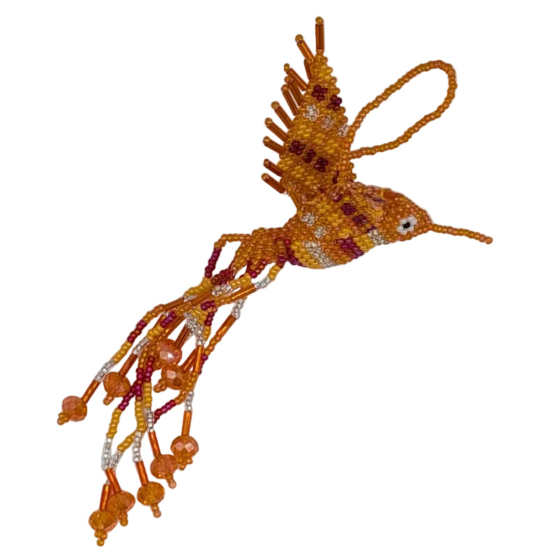 A handmade beaded hummingbird ornament crafted from orange,white, and red seed beads with a small white bead eye and a hanging loop, shown on a plain white background.