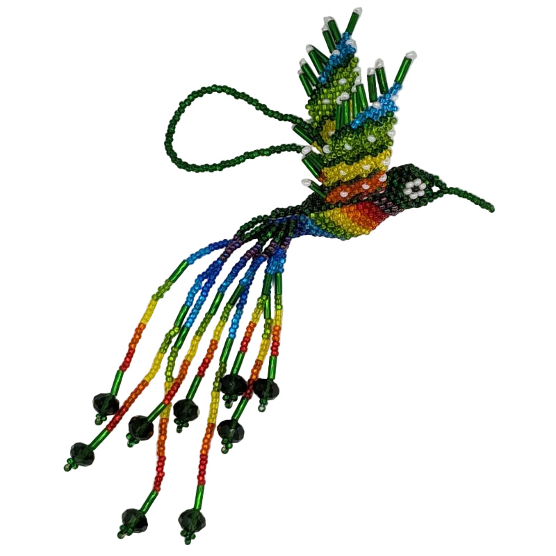 A handmade beaded hummingbird ornament featuring a vibrant rainbow body, green and rainbow wings with white dots, and long trailing rainbow beaded tails with green crystal beads, shown on a plain white background.