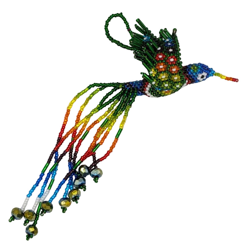 A colorful beaded hummingbird ornament with long trailing strands in rainbow colors and a hanging loop, photographed on a plain white background.