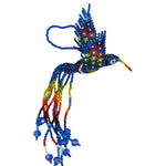 A handmade beaded hummingbird ornament featuring a blue and rainbow body and wings with multicolored accents, and long trailing strands of  beads the colors of the rainbow on a plain white background.