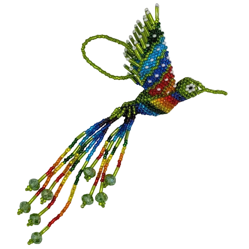 A colorful beaded hummingbird ornament with a lime green body, rainbow patterned wings, and dangling green and colors of the rainbow bead strands on a plain white background.